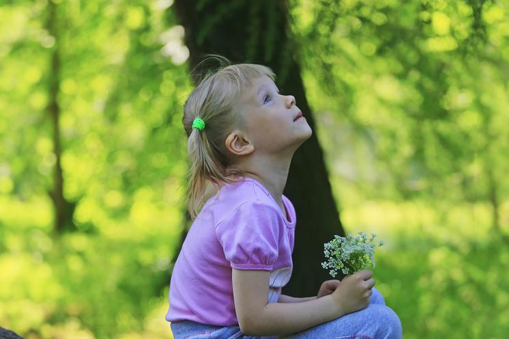 Pige med blomster i naturen